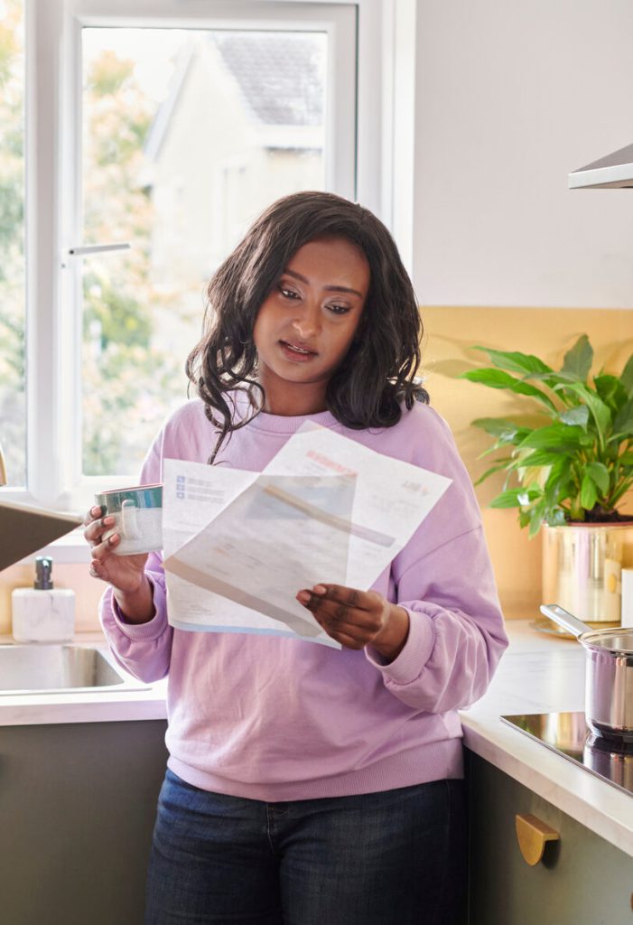 Woman reading an energy bill in her kitchen
