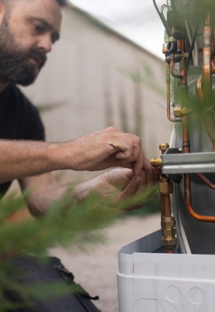 Installer fitting pipework to a heat pump